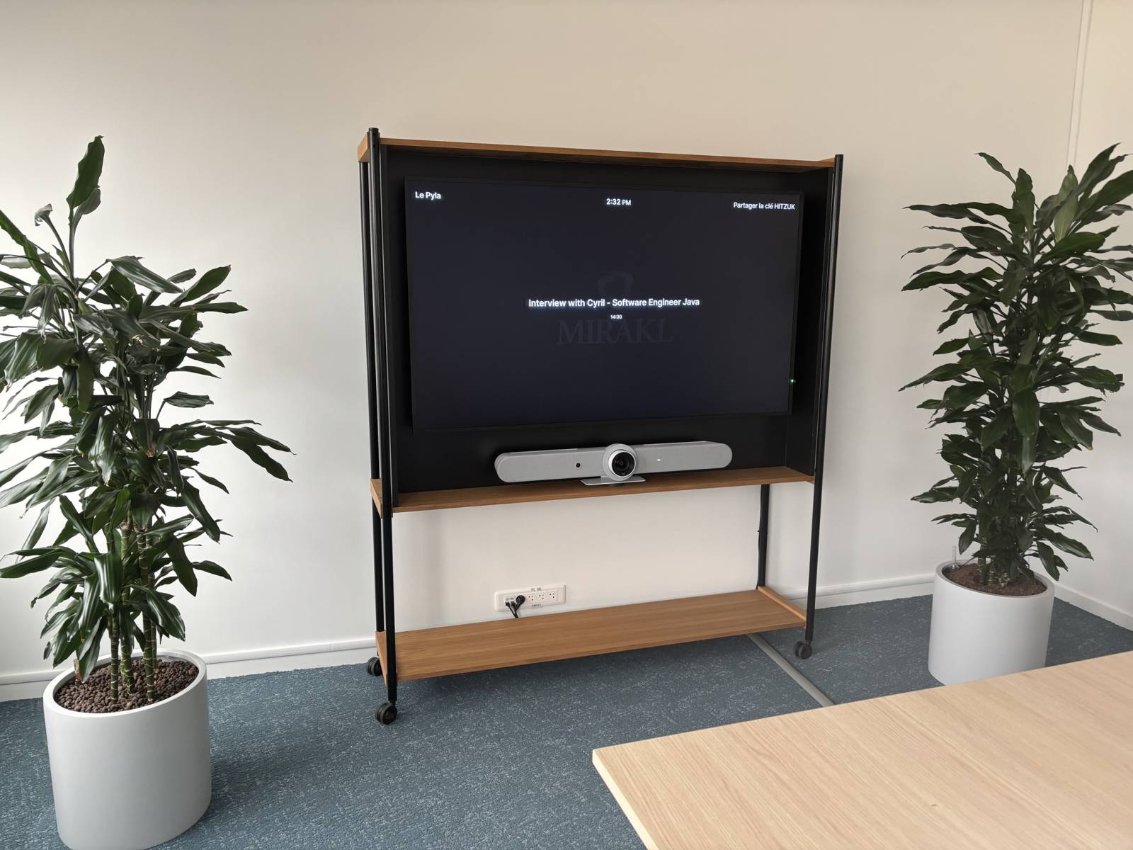 Écran 65 pouces installé avec barre visio Teams Room dans une salle de réunion moderne.