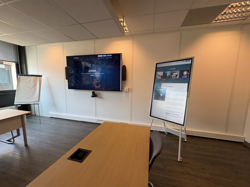Grande salle de réunion moderne équipée d’écrans, caméra, audio professionnel et outils interactifs