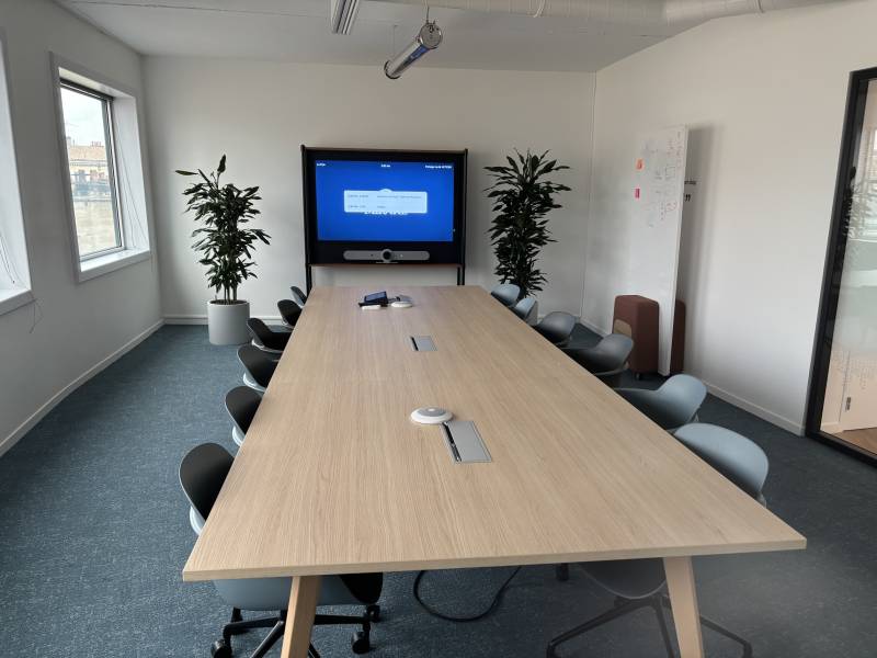Vue d’ensemble d’une salle de réunion avec système de visioconférence intégré et pilotage tactile.