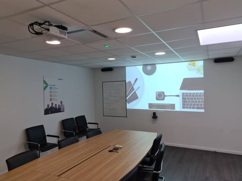 Design moderne et technologie invisible : une salle de réunion sobre, équipée pour la visioconférence sans fil avec ClickShare.