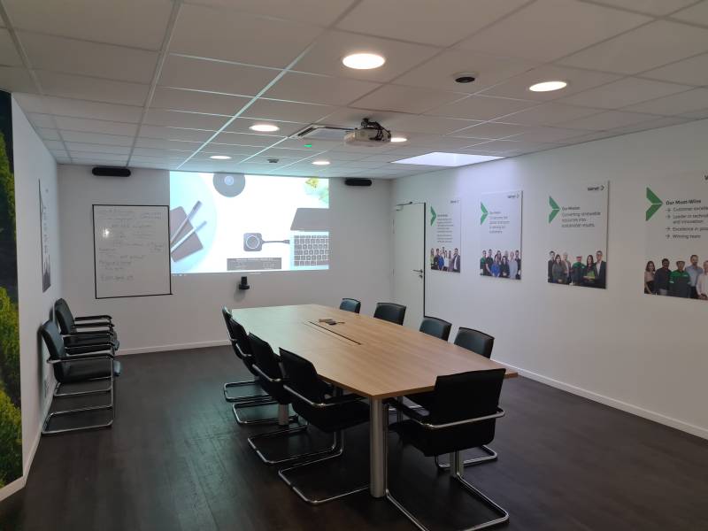 Ambiance épurée et connectée : salle de visioconférence élégante avec projection HD et intégration discrète des micros au plafond.