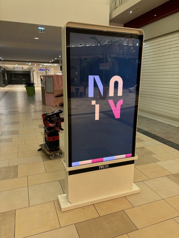 Totem incassable avec affichage dynamique dans une zone de passage fréquentée, mis en place par Jtech à Mérignac.
