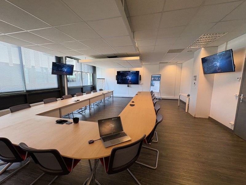 Salle de réunion équipée avec écran principal 86 pouces et écrans de rappel pour une visibilité parfaite