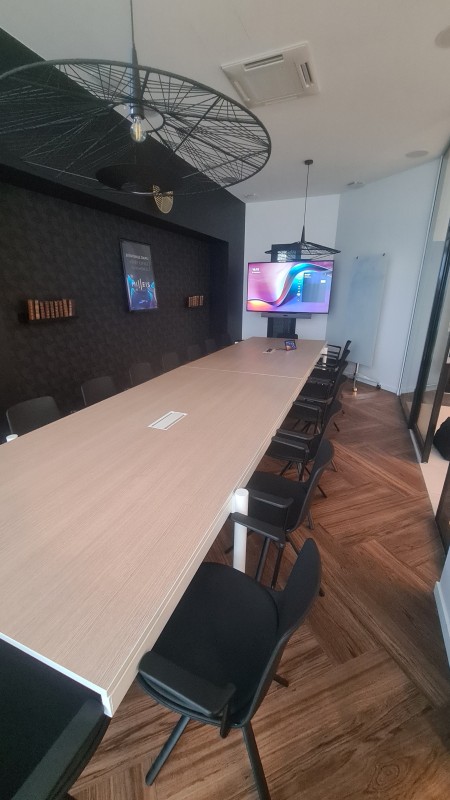 Installation d’une salle de réunion mobile avec écran grand format et barre de son tout-en-un, prête pour vos visioconférences professionnelles.